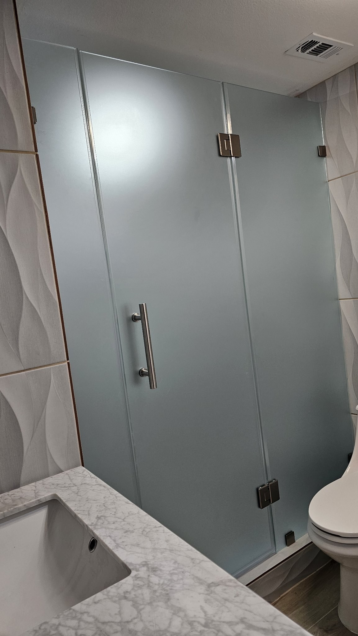 Hinged door with side panels and Frosted glass (privacy) in a wavy tile shower