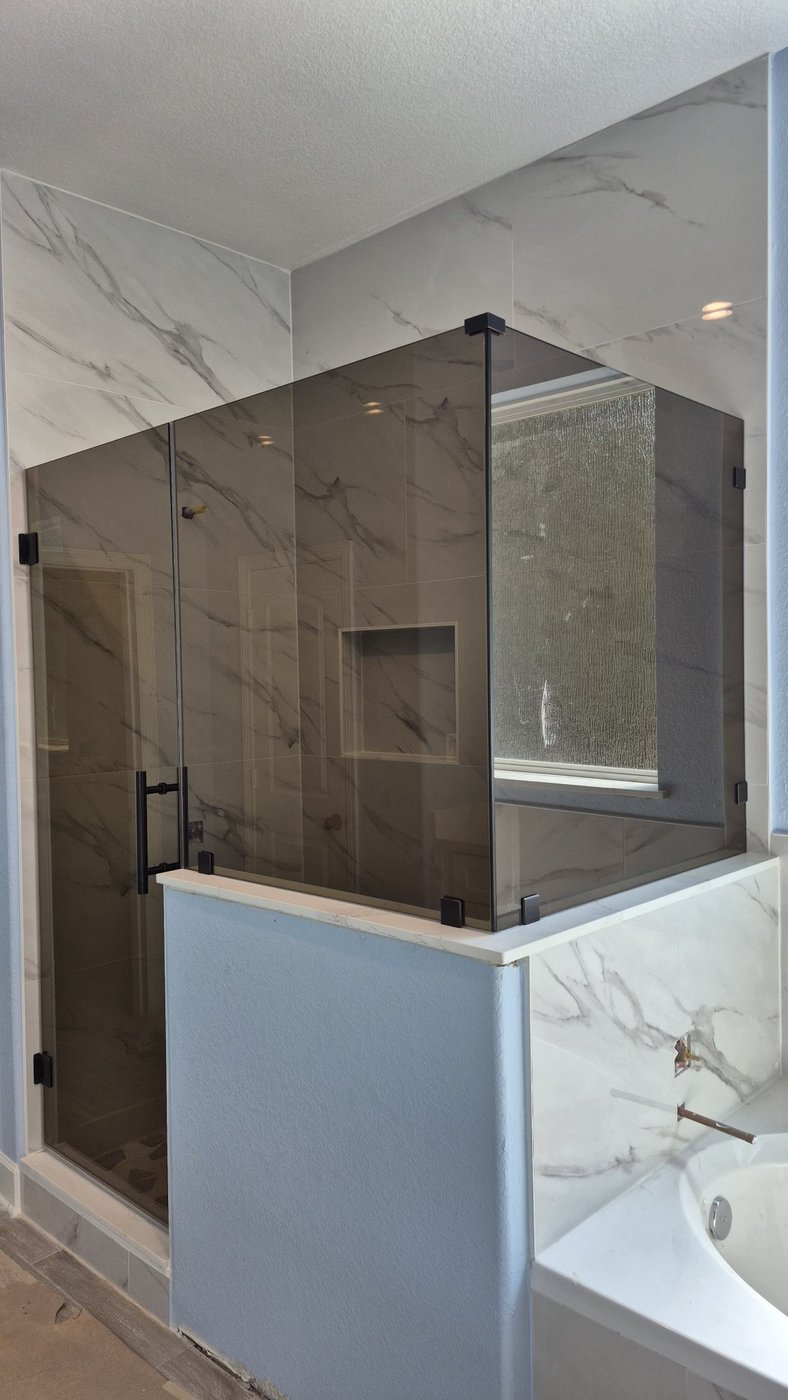 Glas Plus job: 90° angle with smoked glass over a wall next to the tub and black hardware