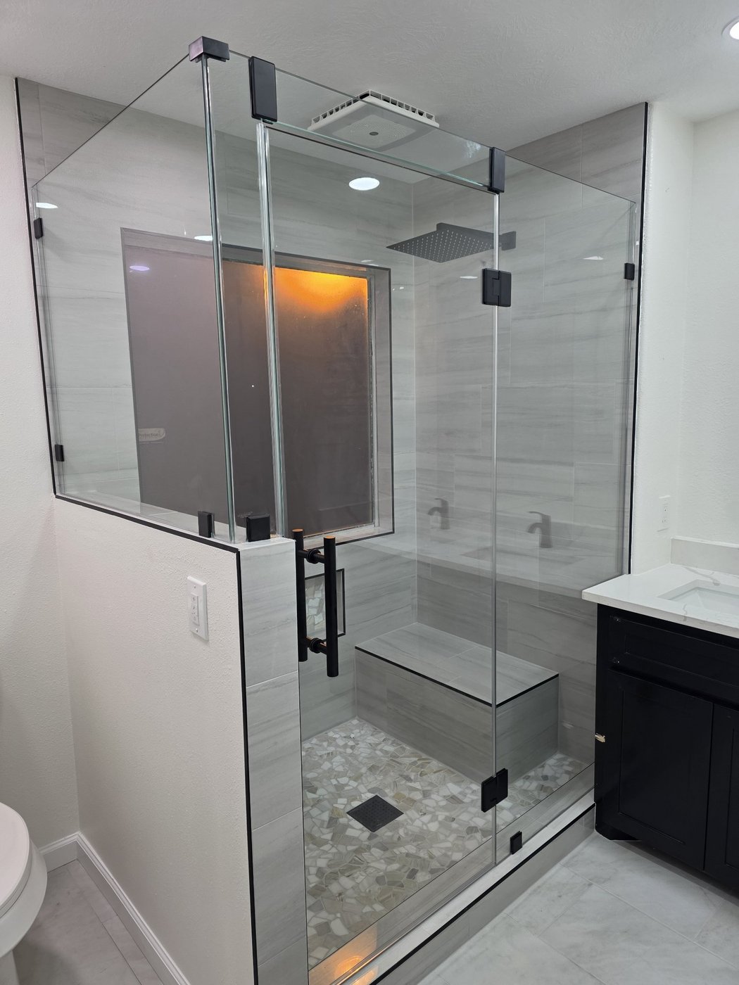 Glas Plus job: 90° angle with glass over a wall and black hardware