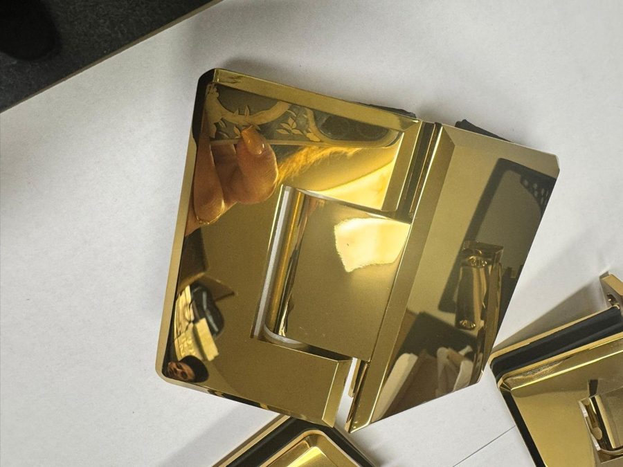 Glas Plus polished gold hinge seen at an angle on a white background