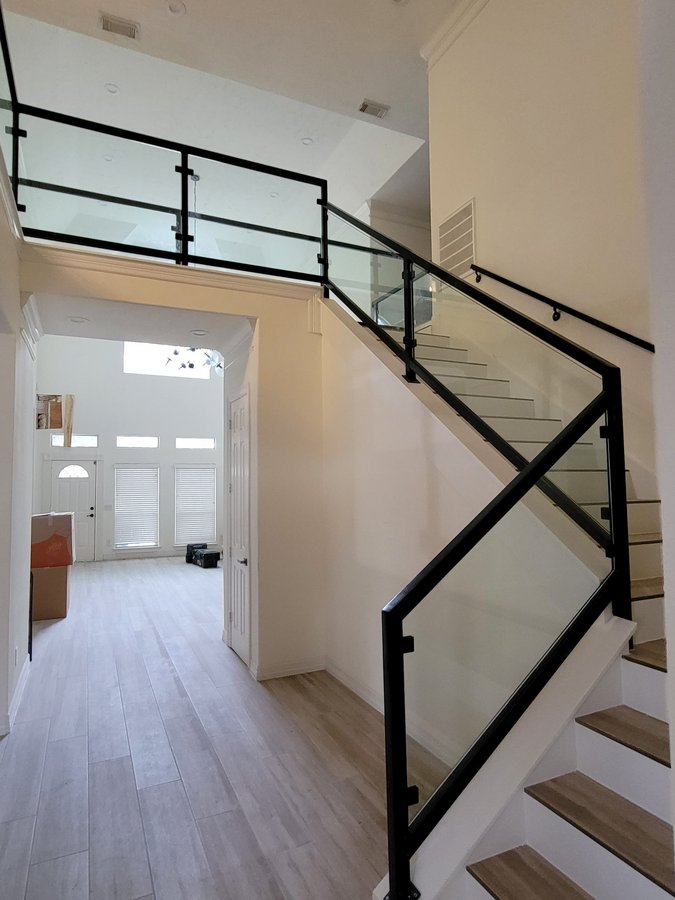 Glas Plus staircases example: glass railing with a black frame on a staircase and upper balcony