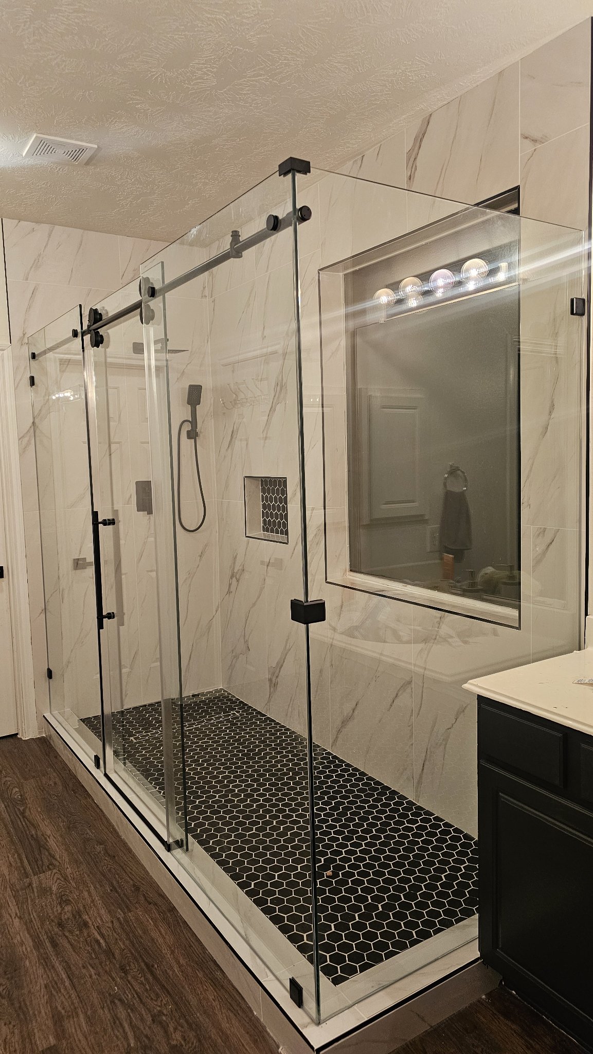 Glas Plus double-door sliding example: two sliding glass doors on a track with black hardware, in a large marble bathroom