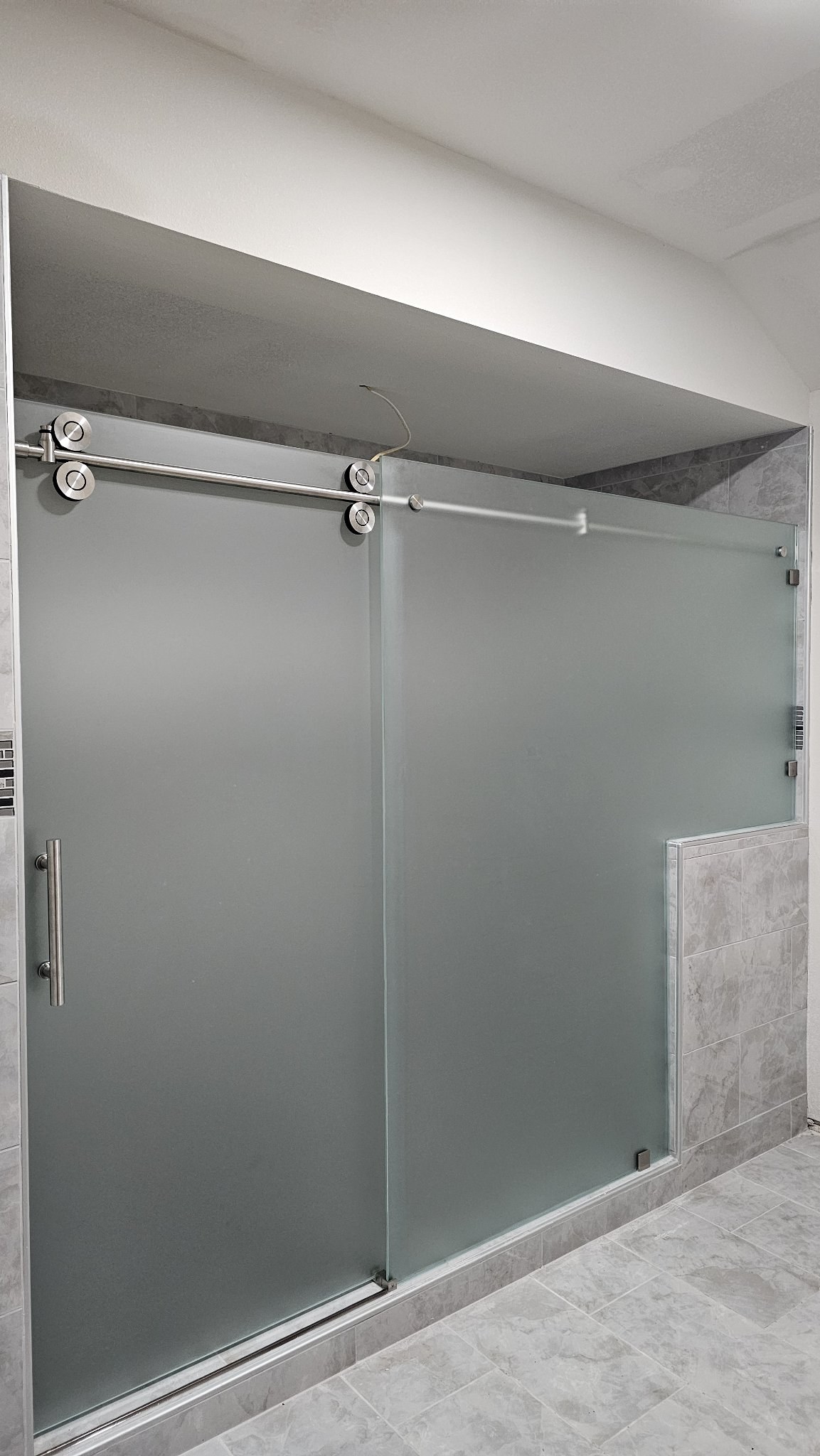 One-door sliding with Frosted glass (privacy), brushed nickel track and fixed panel with notch over a half wall