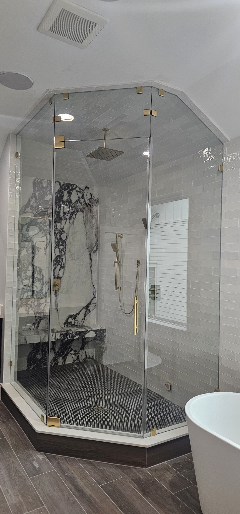 Steam shower door reference photo: glass shower that reaches the ceiling, sauna style, with gold hardware